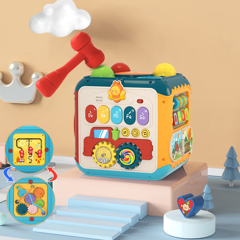 Baby playing with the activity cube on the floor